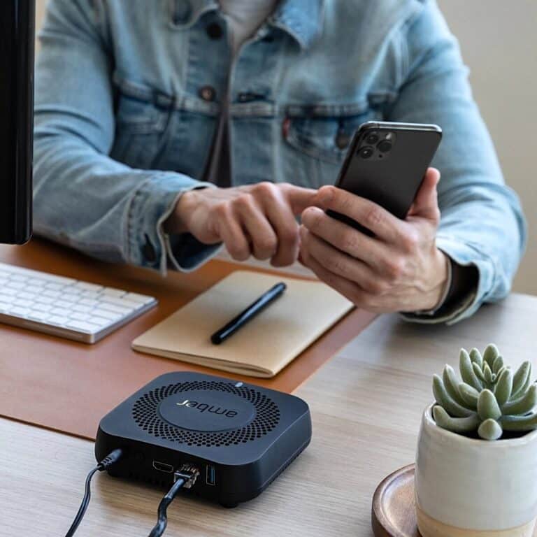 A man using his phone beside an Amber X device