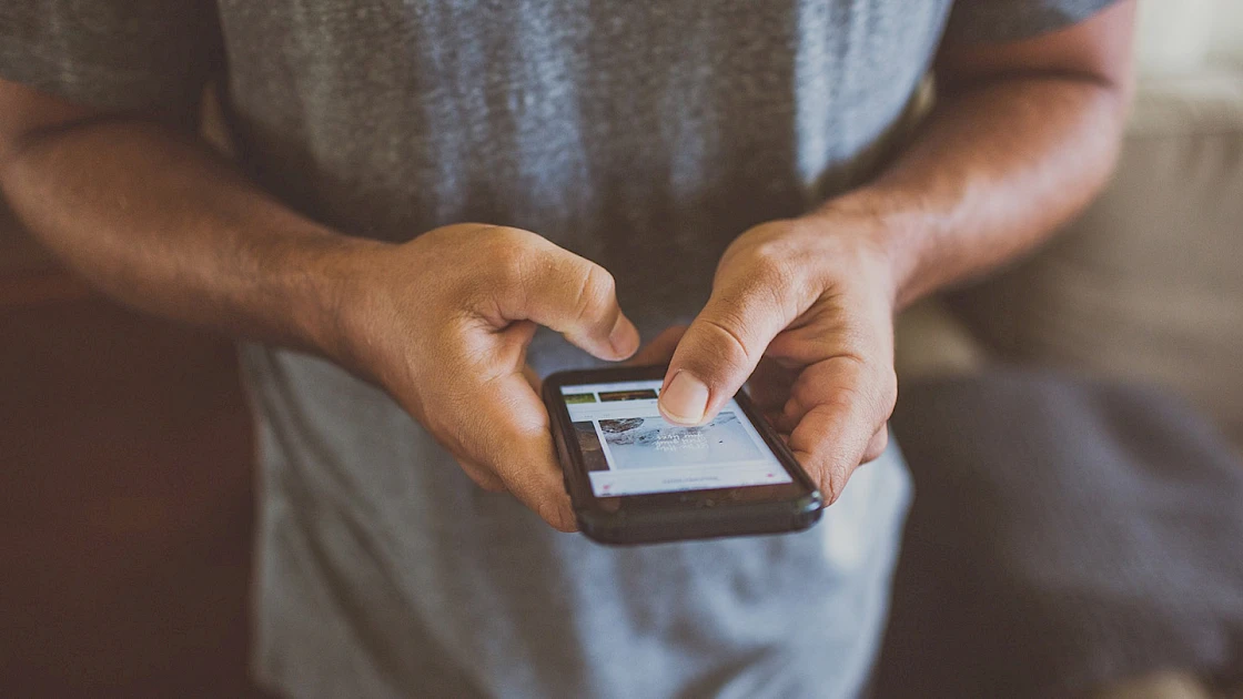 man holding phone and navigating around on it